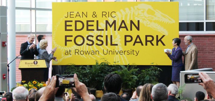 yellow sign unveiled for the Jean & Ric Edelman Fossil Park, as people clap