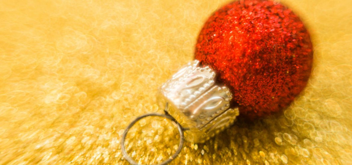 red Christmas ball against a gold background
