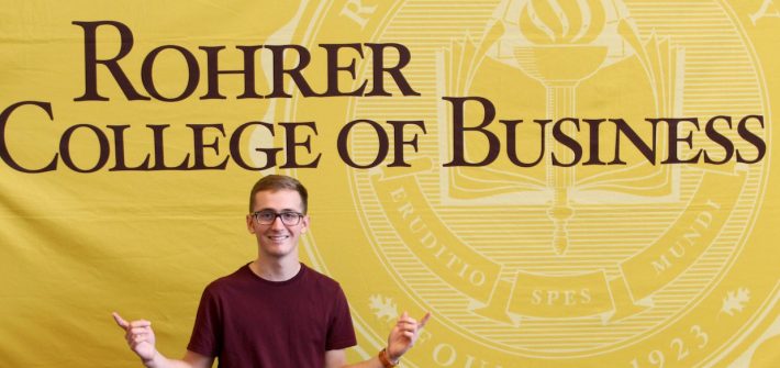 Kyle in front of Rohrer College of Business sign