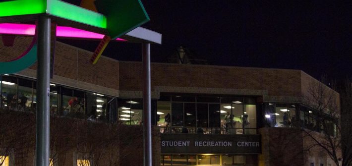 Front of Rec Center at night, with brightly illuminated abstract art in front