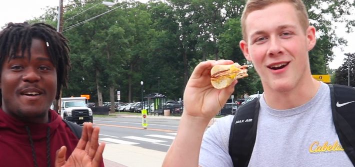 Two Rowan University Students eating a pork roll sandwich