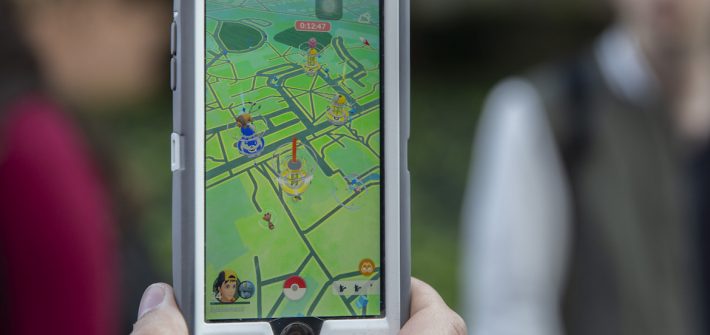 a close-up of a student holding a phone with the pokemon go app open.