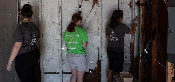 First-Year Volunteer Connection student leader Rose Dickmann (center, in green) helps out at the St. Bernard's disaster relief project.
