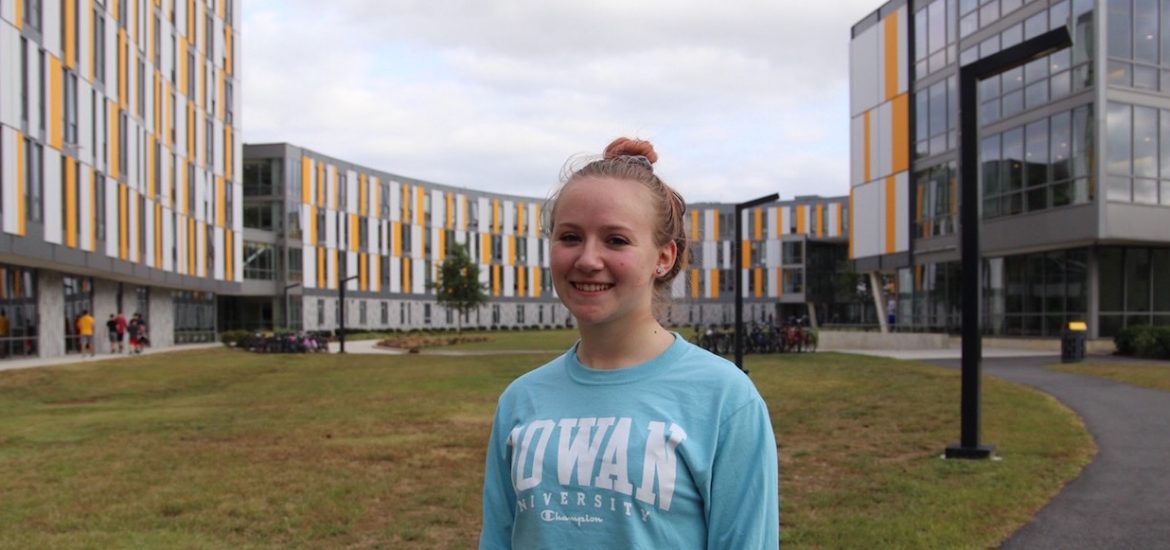 Elizabeth Hudak stands in front of Holly Pointe Commons at Rowan University with the building behind her