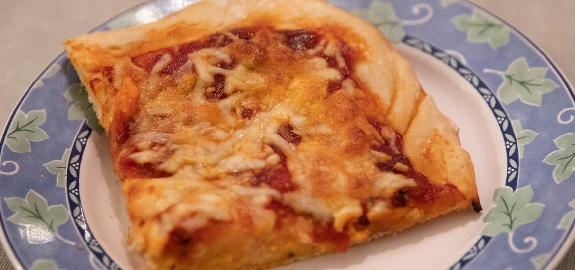 A Sicilian slice of pizza on a plate.