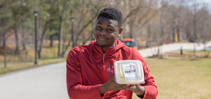 Robert Brown poses with Freshens rice bowl on campus.
