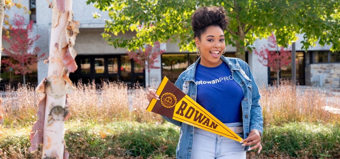 Cheyenne holds a pennant on campus.