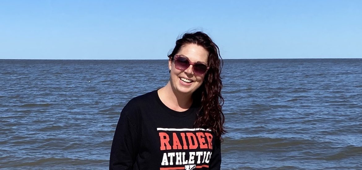A photo of Heather outside at the beach wearing sunglasses.