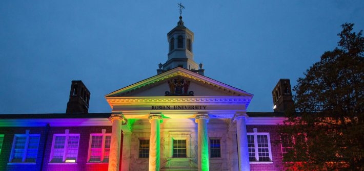 An exterior shot of Bunce Hall is illuminated in rainbow colors for Pride Month.