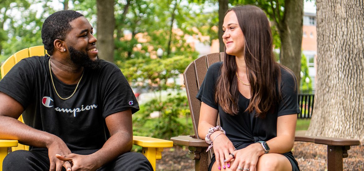 Natalie sits with her coworker Reshaun on campus.