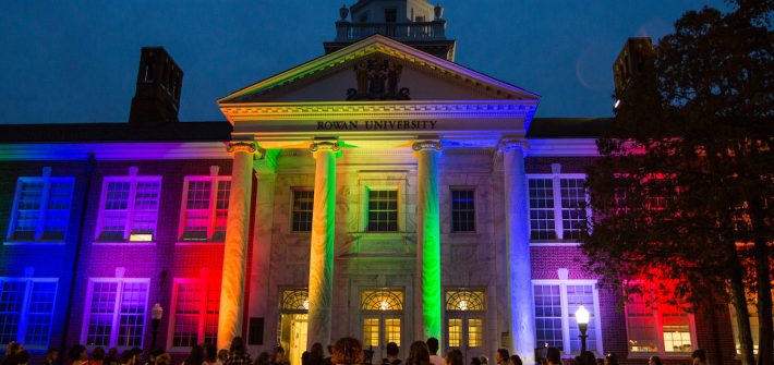 Exterior shot of Bunce Hall lit in Pride colors.