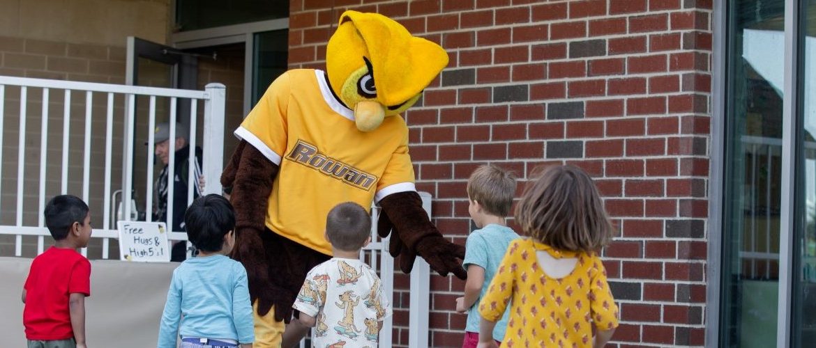Prof mascot playing with kids.