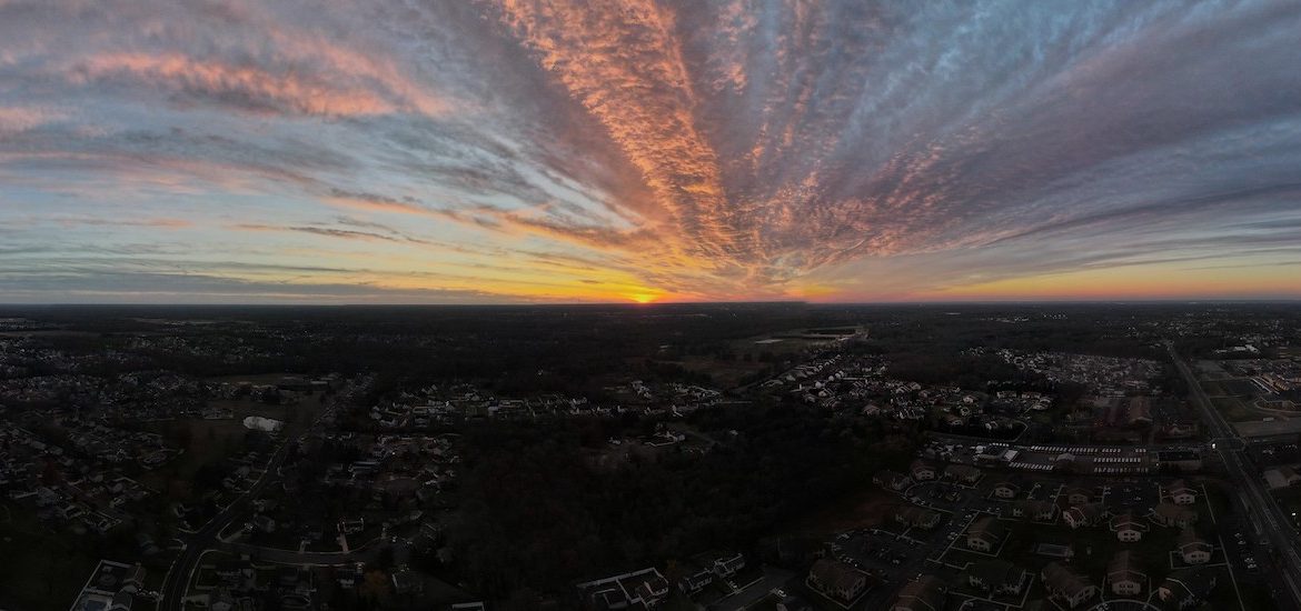 Dramtically colored sunset over the town of Glassboro, as seen from a drone.