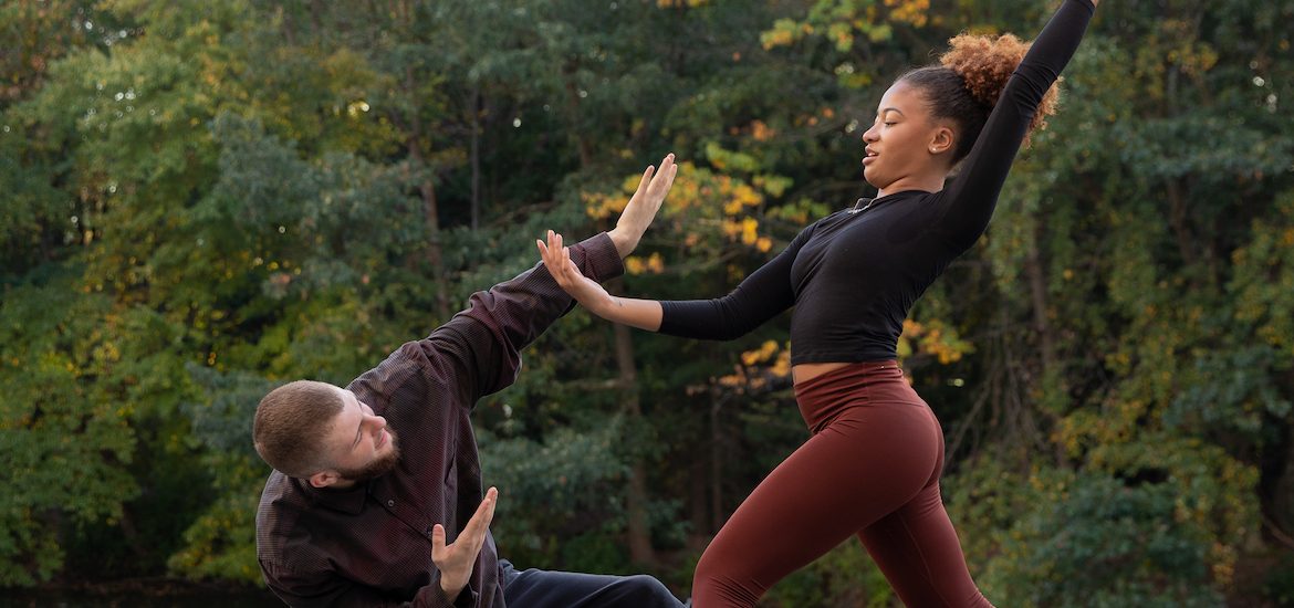 Two dancers in mid-pose outdoors.